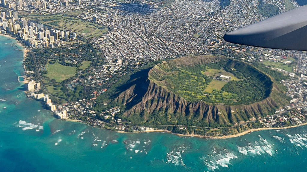 An aerial view from the window of a plane shows Diamond Head crater in Oahu, Hawaii